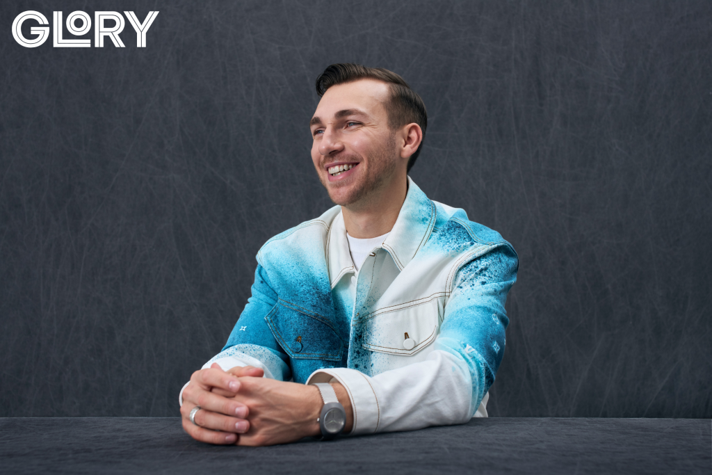Maple Leafs Michael Bunting poses in a blue and white jacket for a photoshoot