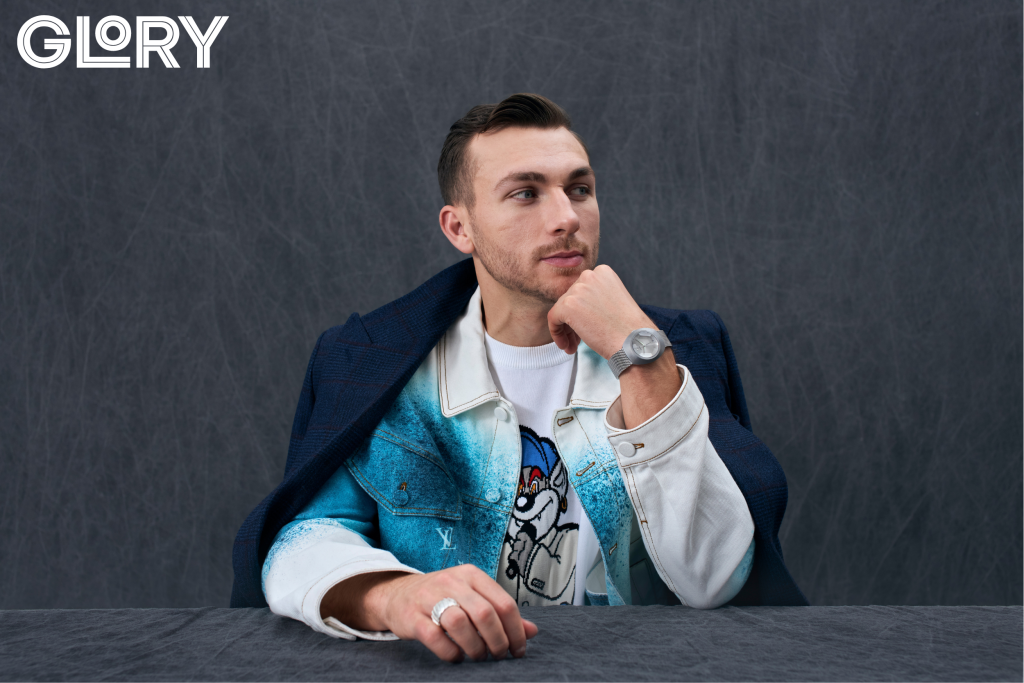 Maple Leafs Michael Bunting poses in a blue and white jacket for a photoshoot