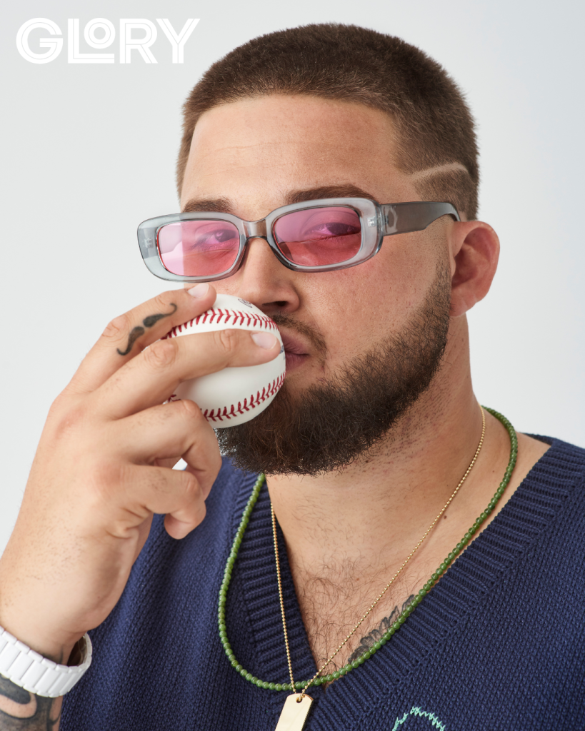 Alek Manoah wearing pink sunglasses and kissing baseball