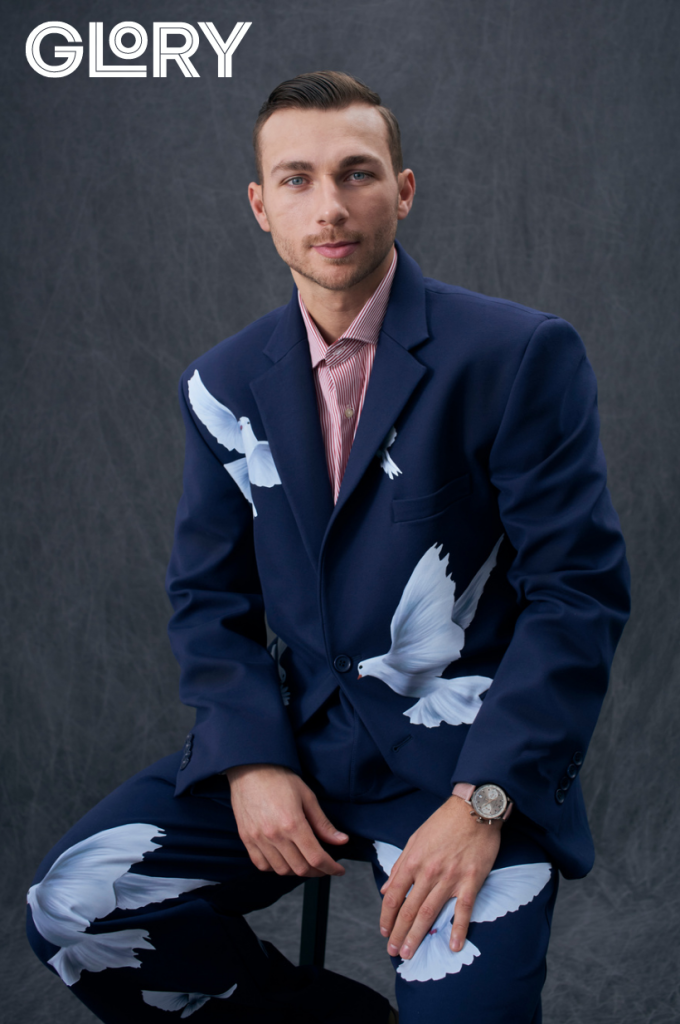 Michael Bunting sits on a stool for a portrait wearing a blue and white suit.