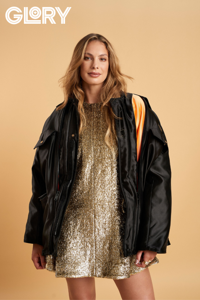 Penny Oleksiak wearing gold dress and black parka